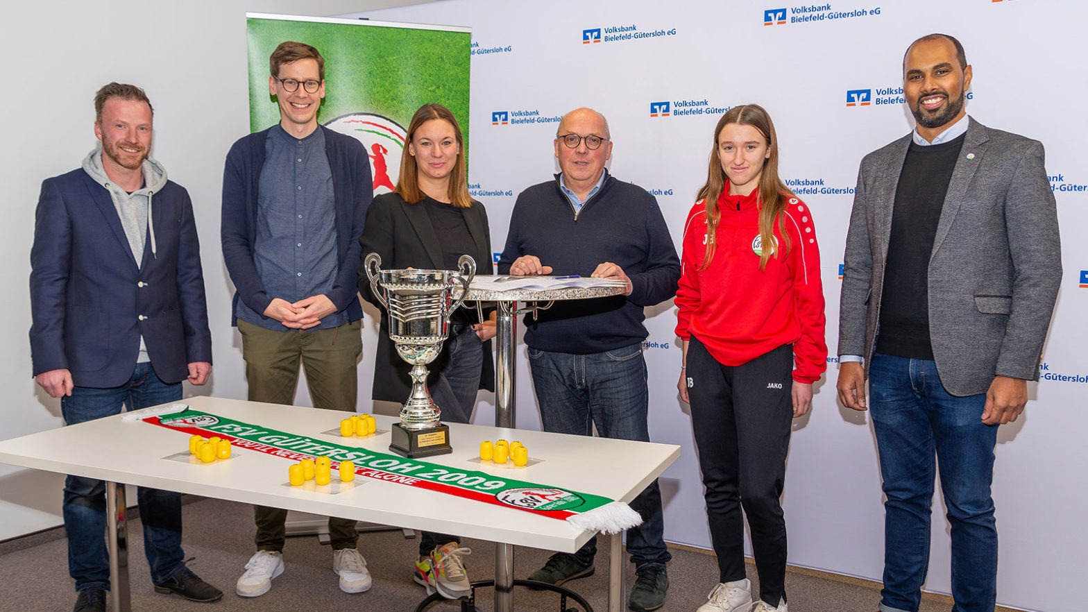 Zufriedene Gesichter bei der Auslosung für das Gütersloher Hallenmasters 2023 um den Volksbank-Cup: Tobias Neumann, Matthias Boerger, Karina Wiemann, Michael Horstkötter, Johanna Burholz und Chris Punnakkattu Daniel. (Foto: Boris Kessler / FSV Gütersloh 2009)