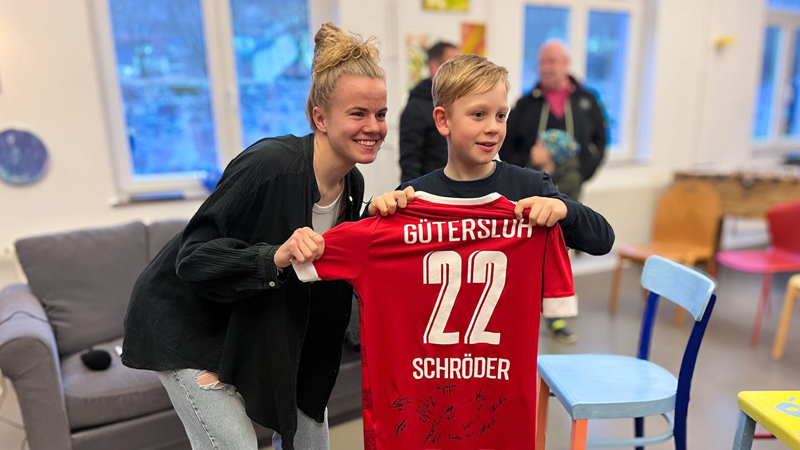 FSV-Angreiferin Marie Schröder übergibt ein signiertes FSV-Trikot an den Gewinner der Verlosung. (Foto: IQ Lügde)